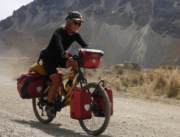 Kate Rawles cycling on a bamboo bike on a unmade road in Cordillera Blanca, Peru.