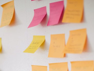 Sticky notes with writing on stuck to a wall.