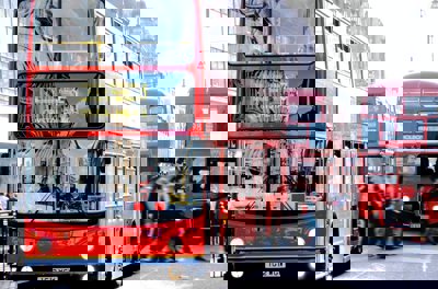 Two red London buses side by side on the street